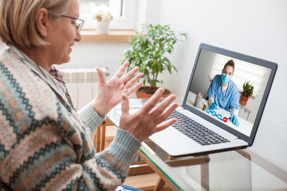 Elderly caucasian woman interacting with young female doctor via chat video call